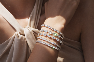 Stacked diamond tennis bracelets with mixed cuts on wrist in soft sunlight