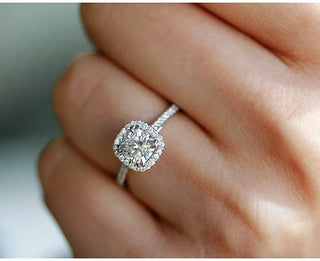 Close-up of a moissanite engagement ring sparkling brilliantly next to a diamond ring, highlighting visual similarities and affordability appeal.