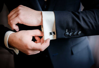 Stylish man wearing layered bracelets and rings, showcasing how to wear men’s jewelry with balance and confidence.