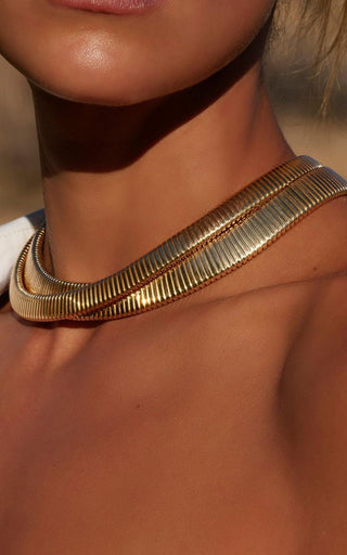 A comparison of 24K, 18K, and 14K gold jewelry pieces laid side by side, highlighting variations in color and purity.
