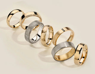 Couple holding hands wearing matching wedding bands, symbolizing love and unity