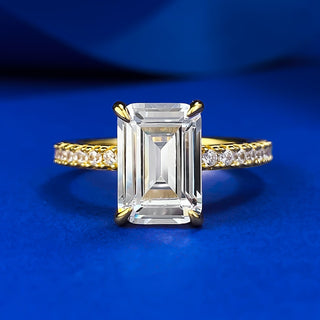 Sterling silver ring with an emerald-cut moissanite centerpiece in a classic prong setting, showcasing minimalist elegance.
