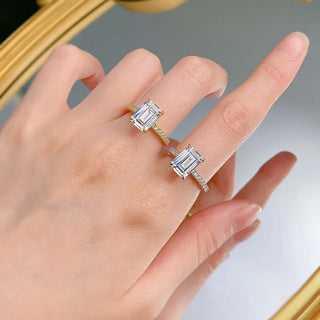 Sterling silver ring with an emerald-cut moissanite centerpiece in a classic prong setting, showcasing minimalist elegance.