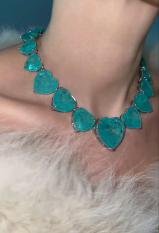 Heart of Ocean Necklace and earrings set with sea-blue crystal hearts in silver-copper blend, inspired by ocean depths and timeless romance.

