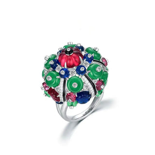 Azzallure's Trinity Gem Ring showcasing a sculptural cluster of vibrant carved gemstones in green, red, and blue, accented with sparkling white stones. Set in sterling silver, this bold statement ring reflects the signature elegance of the Trinity collection.
