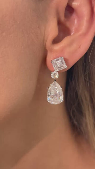 The Celestial Drops earrings: 18K white gold drop earrings with a 4 ct Asscher-cut, 0.5 ct round, and 10 ct pear-shaped lab-grown diamonds (29 ct total).