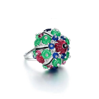 Azzallure's Trinity Gem Ring from side angle showcasing a sculptural cluster of vibrant carved gemstones in green, red, and blue, accented with sparkling white stones. Set in sterling silver, this bold statement ring reflects the signature elegance of the Trinity collection.